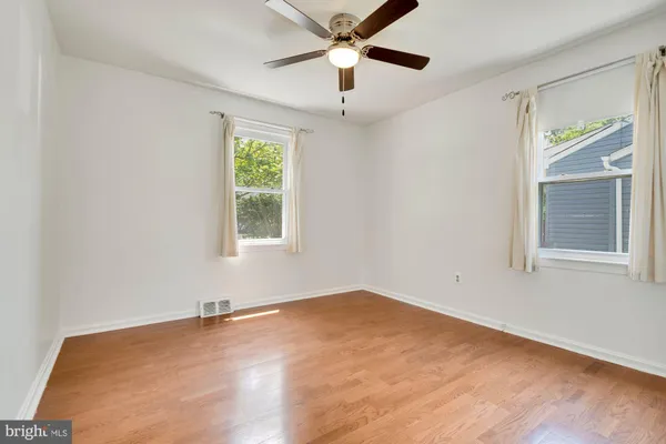 a view of a big room with windows and chandelier fan