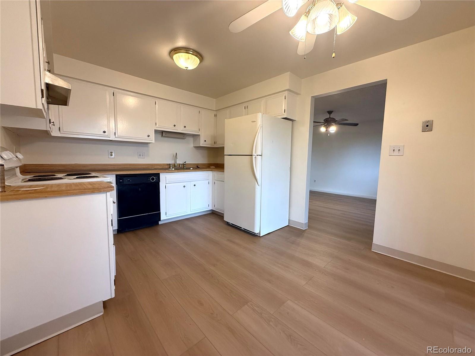6155 Simms Street, Unit 2 Arvada, CO 80004 - Photo 4 of 7 a kitchen with stainless steel appliances granite countertop a refrigerator and a stove top oven
