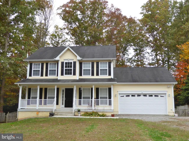 a front view of a house with a yard garage and trees