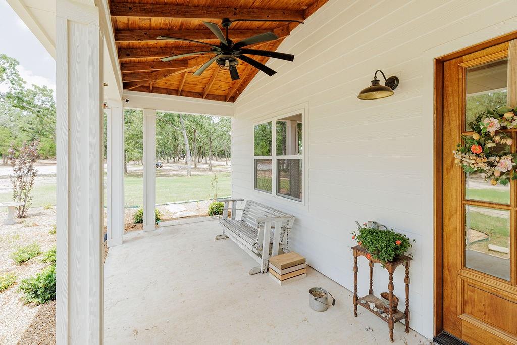 2094 Jim Harry Loop Sunset, TX 76270 - Photo 27 of 40 covered front porch with wood-finish vaulted ceiling and ceiling fan, hardy backer siding