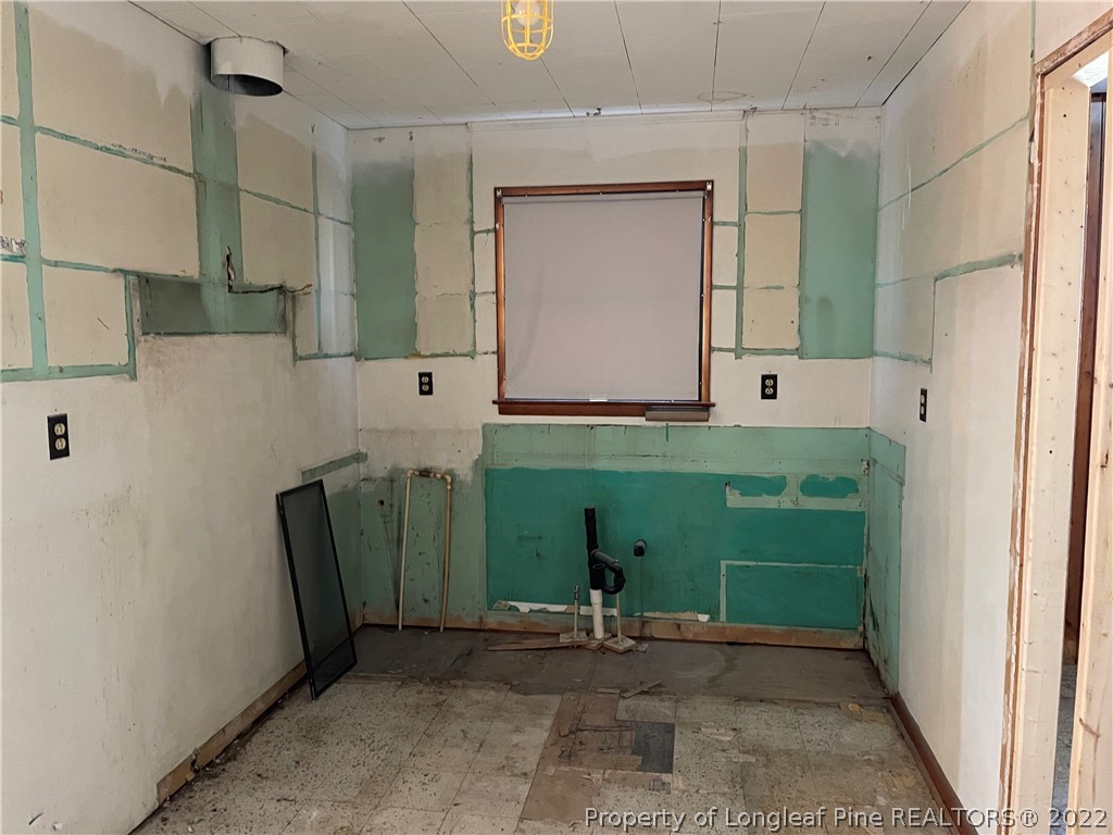 6990 Rockfish Road Fayetteville, NC 28306 - Photo 11 of 12 a bathroom with a sink a toilet and a mirror
