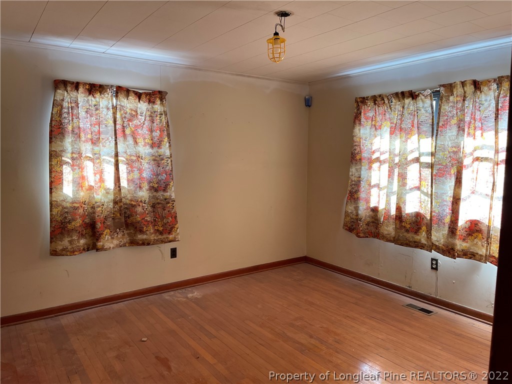 6990 Rockfish Road Fayetteville, NC 28306 - Photo 8 of 12 an empty room with wooden floor and windows
