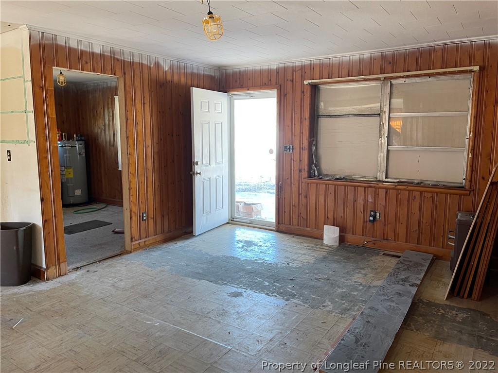 6990 Rockfish Road Fayetteville, NC 28306 - Photo 10 of 12 an empty room with sliding door and wooden floor
