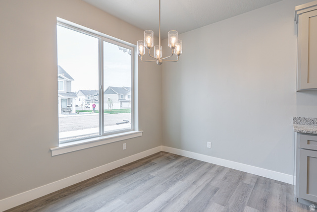 2257 South 1090 West, Unit 74 Nibley, UT 84321 - Photo 5 of 40 Dining area featuring a large window, wood-finish flooring, a contemporary chandelier, light gray walls, and white baseboards