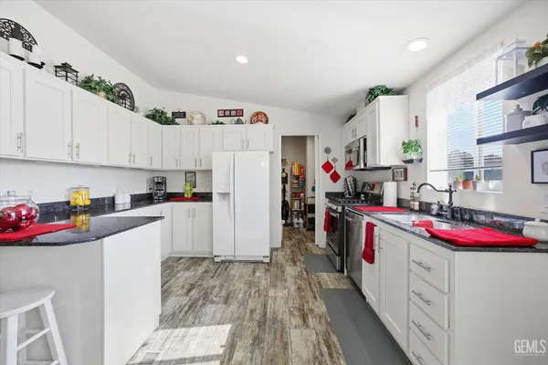 a kitchen with cabinets a sink and white appliances