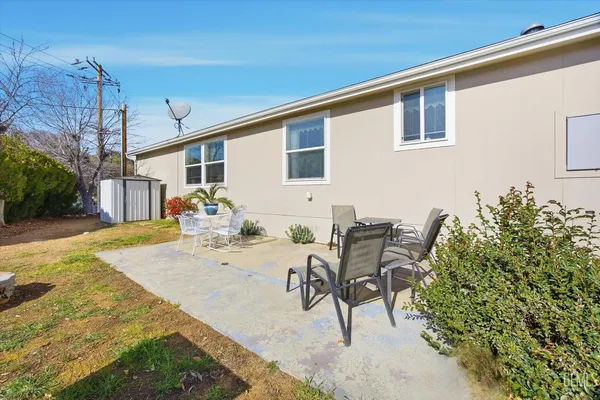 a view of a backyard with furniture and a garden