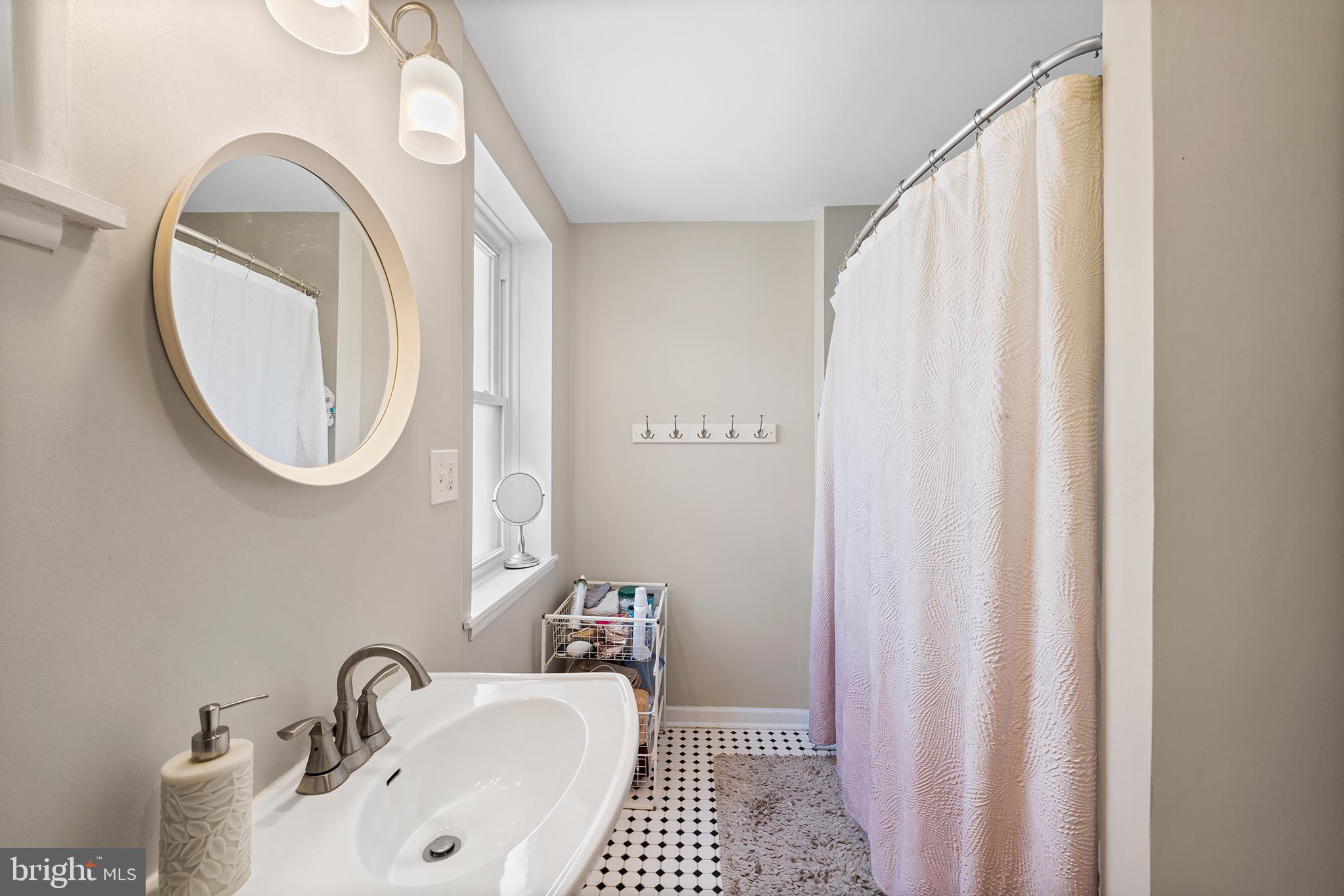 107 Master Street Philadelphia, PA 19122 - Photo 18 of 24 a bathroom with a sink a mirror and a bathtub