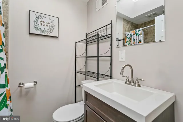 a bathroom with a sink mirror and toilet