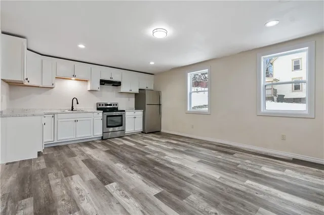 a kitchen with granite countertop a stove cabinets and a refrigerator