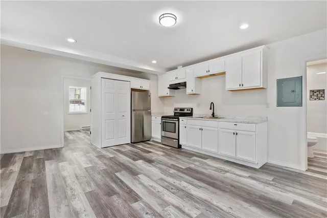 a kitchen with white cabinets and stainless steel appliances