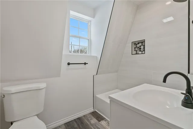 a bathroom with a sink a toilet and a mirror