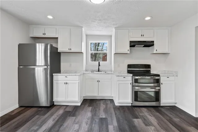 a kitchen with white cabinets and stainless steel appliances
