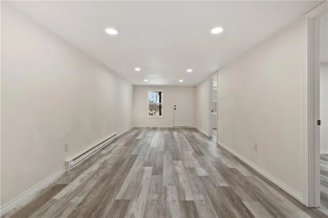 a view of empty room with wooden floor