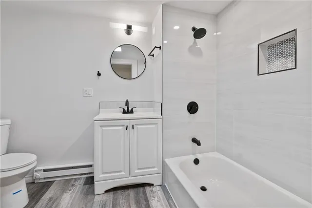 a bathroom with a white tub a sink and a mirror