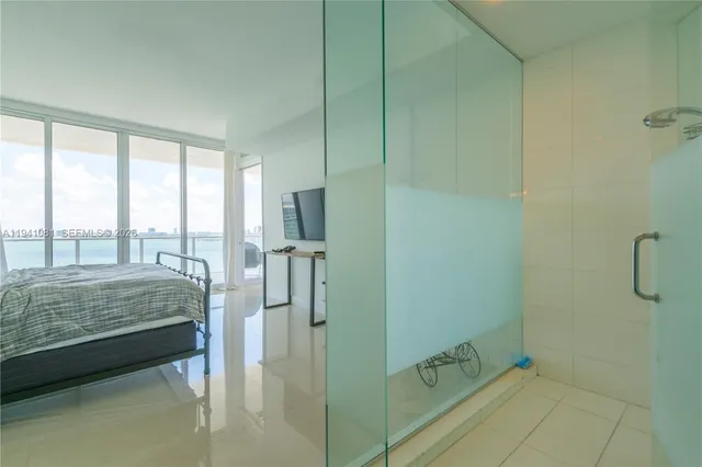 a bathroom with a tub a sink and glass door