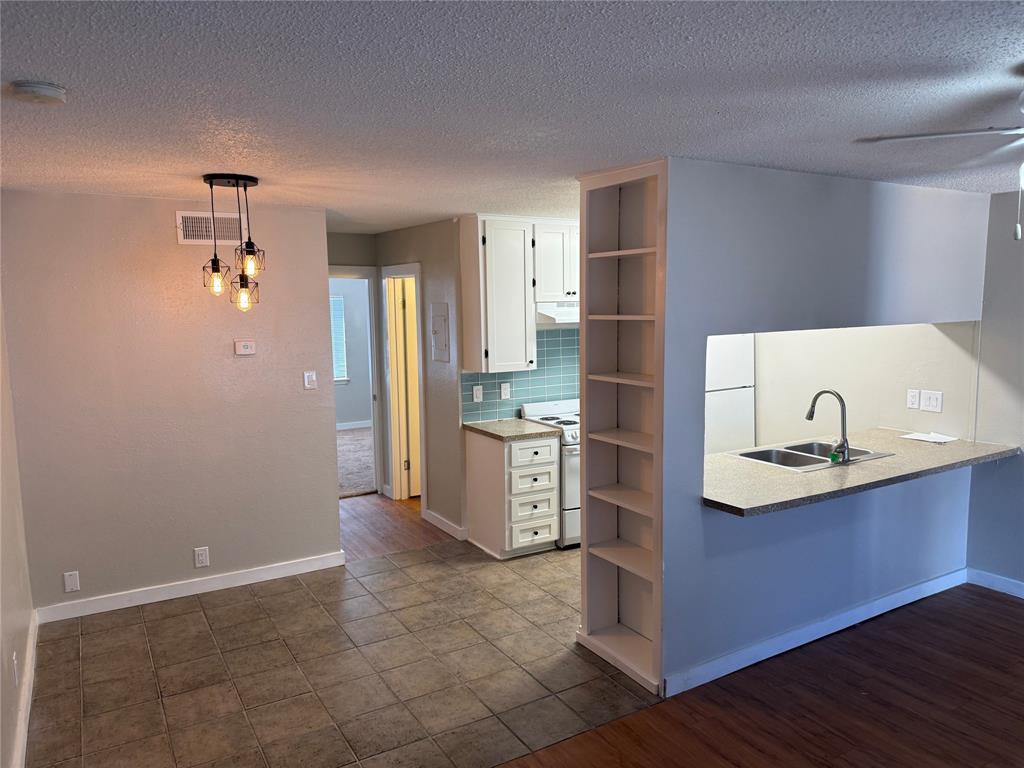 a kitchen with kitchen island granite countertop a sink cabinets and stainless steel appliances