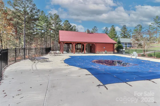 a sign board with a big yard and large trees