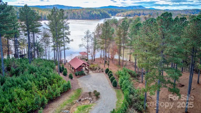 a view of a house with a yard and large trees