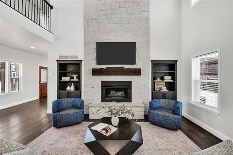 a living room with furniture a flat screen tv and a fireplace