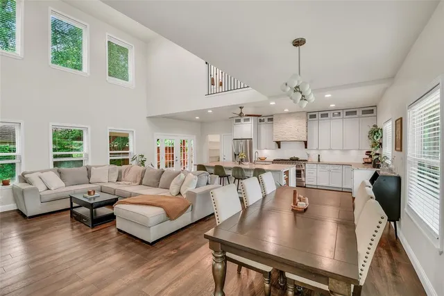 a living room with furniture kitchen view and a wooden floor