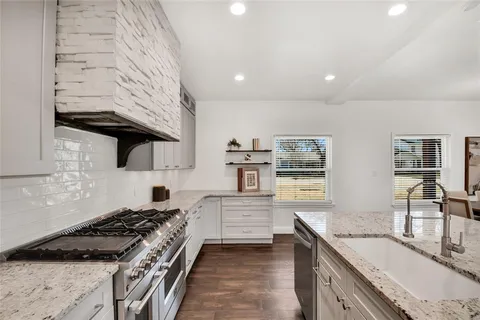 a kitchen with granite countertop a stove and a sink
