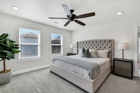 a bedroom with a large bed and a potted plant