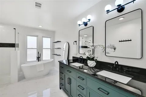 a bathroom with a double vanity sink a mirror and a shower