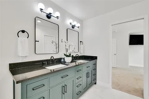a bathroom with a double vanity sink and a mirror