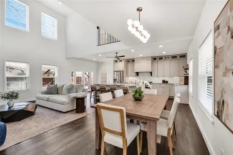 a view of a dining room with furniture a kitchen and chandelier