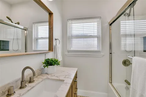 a bathroom with a shower sink and mirror