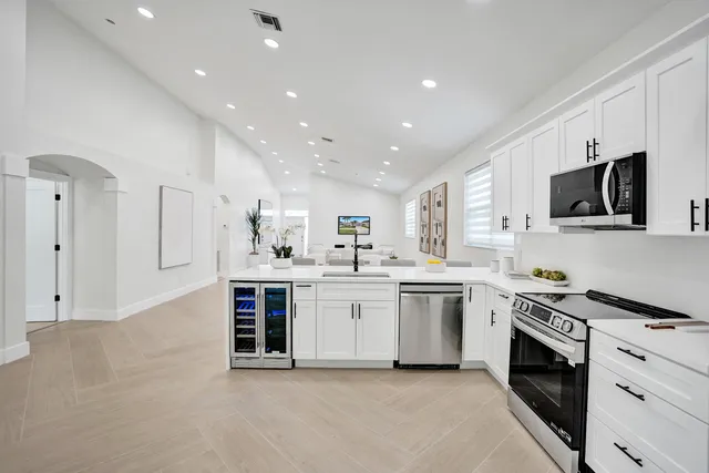 a kitchen with white cabinets and stainless steel appliances