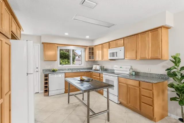 a kitchen with a cabinets a sink and chairs in it