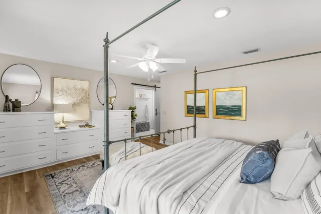 a bedroom with a bed a potted plant and a large mirror