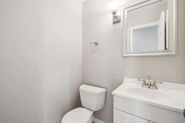 a bathroom with a granite countertop sink a toilet and a mirror
