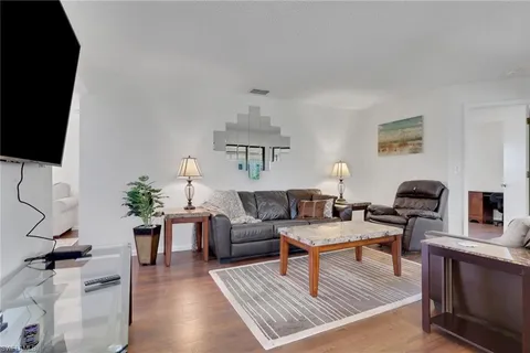 a living room with furniture a rug and a flat screen tv