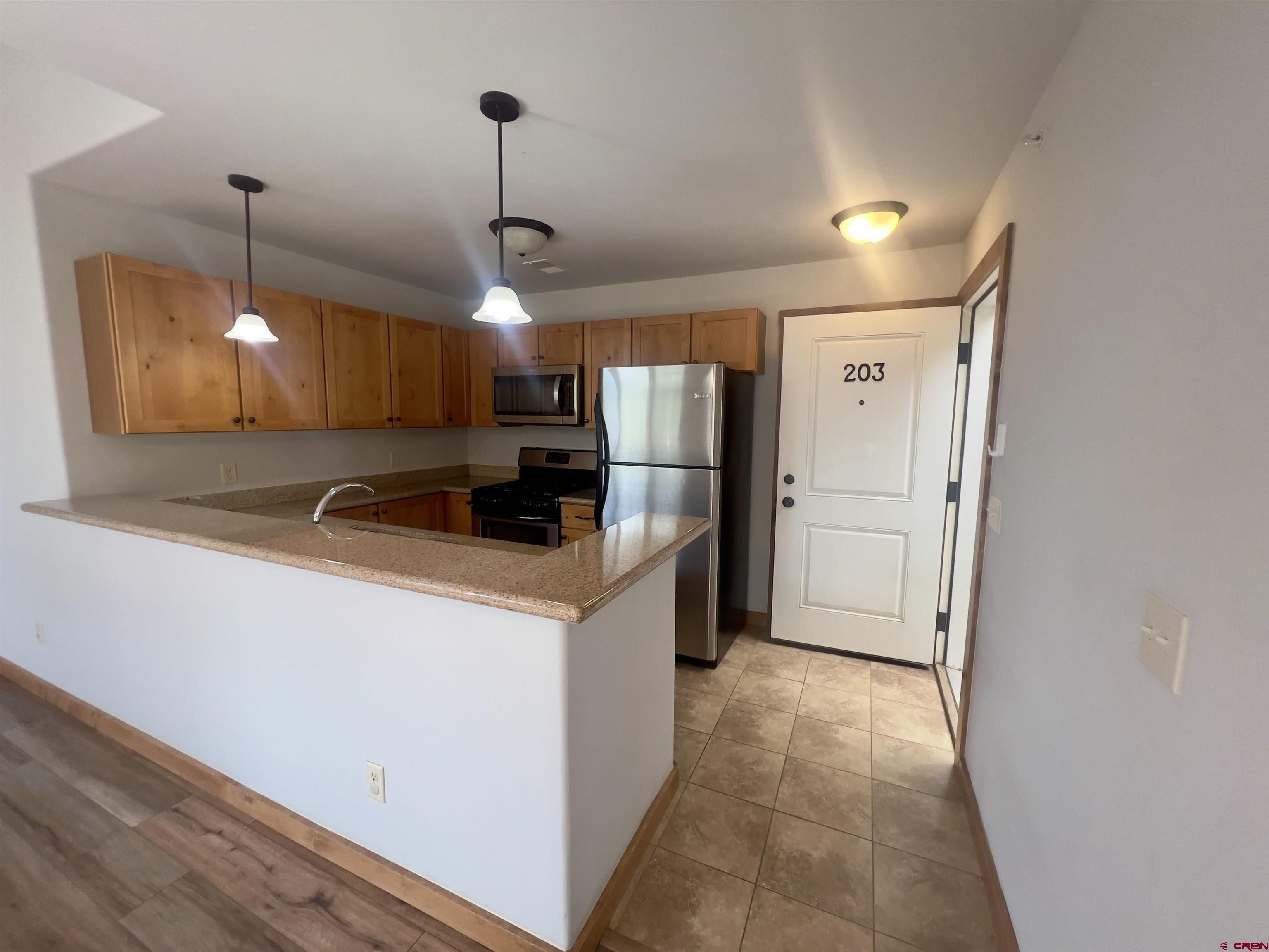 540 Redcliff Circle, Unit E 203 Ridgway, CO 81432 - Photo 4 of 36 a kitchen with stainless steel appliances a refrigerator sink and microwave