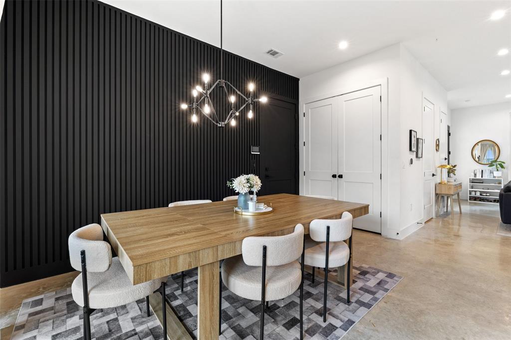 5007 Lott Avenue, Unit 1 Austin, TX 78721 - Photo 10 of 24 A striking black accent wall complements the modern dining area, illuminated by a contemporary chandelier.
