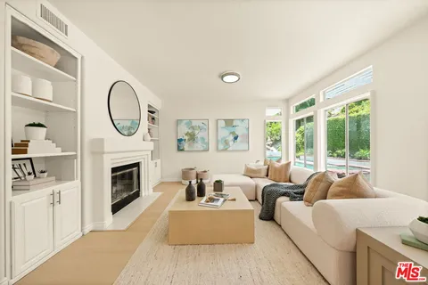 a living room with furniture a fireplace and a large window