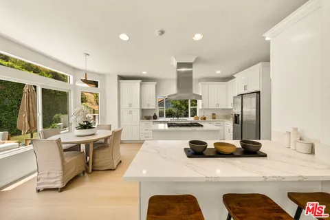 a kitchen with stainless steel appliances granite countertop a sink refrigerator and cabinets