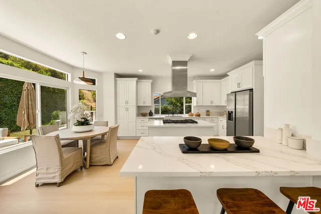 a kitchen with stainless steel appliances granite countertop a sink refrigerator and cabinets