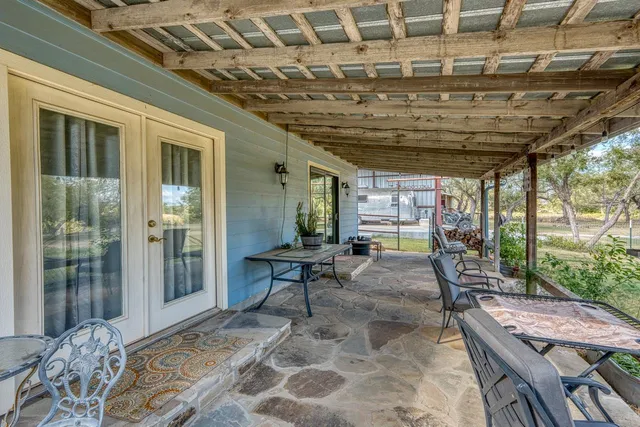 a view of a porch with a table and chairs