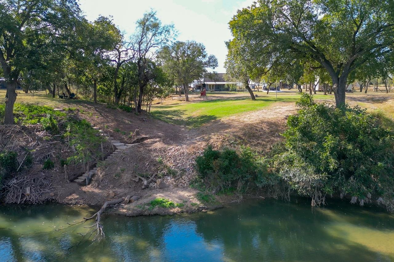 352 Keller Velino Road Mason, TX 76856 - Photo 6 of 25 a view of a swimming pool with a yard and large trees