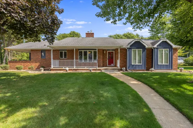a view of a house with a chairs and table in a yard
