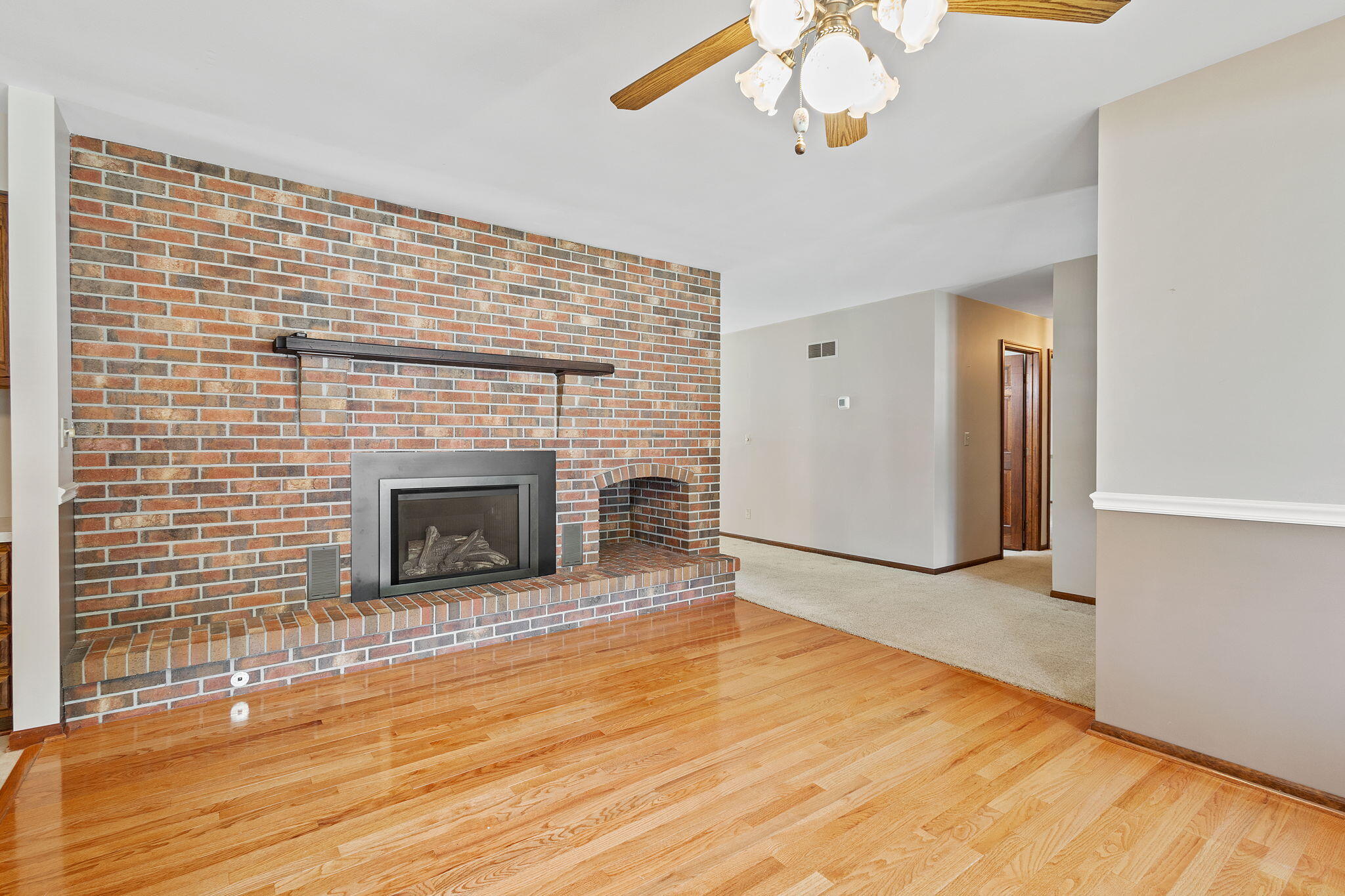 1905 Juniper Street Southwest De Motte, IN 46310 - Photo 7 of 42 a view of an empty room with wooden floor and a fireplace