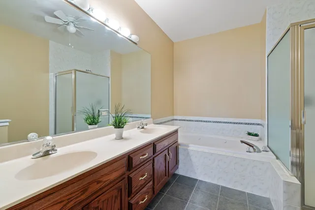 a spacious bathroom with a tub sink and mirror