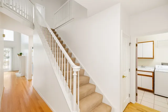 a view of a hallway with wooden floor and staircase