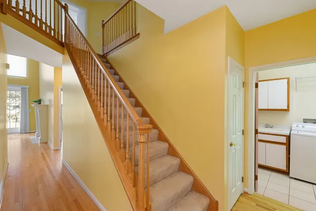 a view of a hallway with wooden floor and staircase