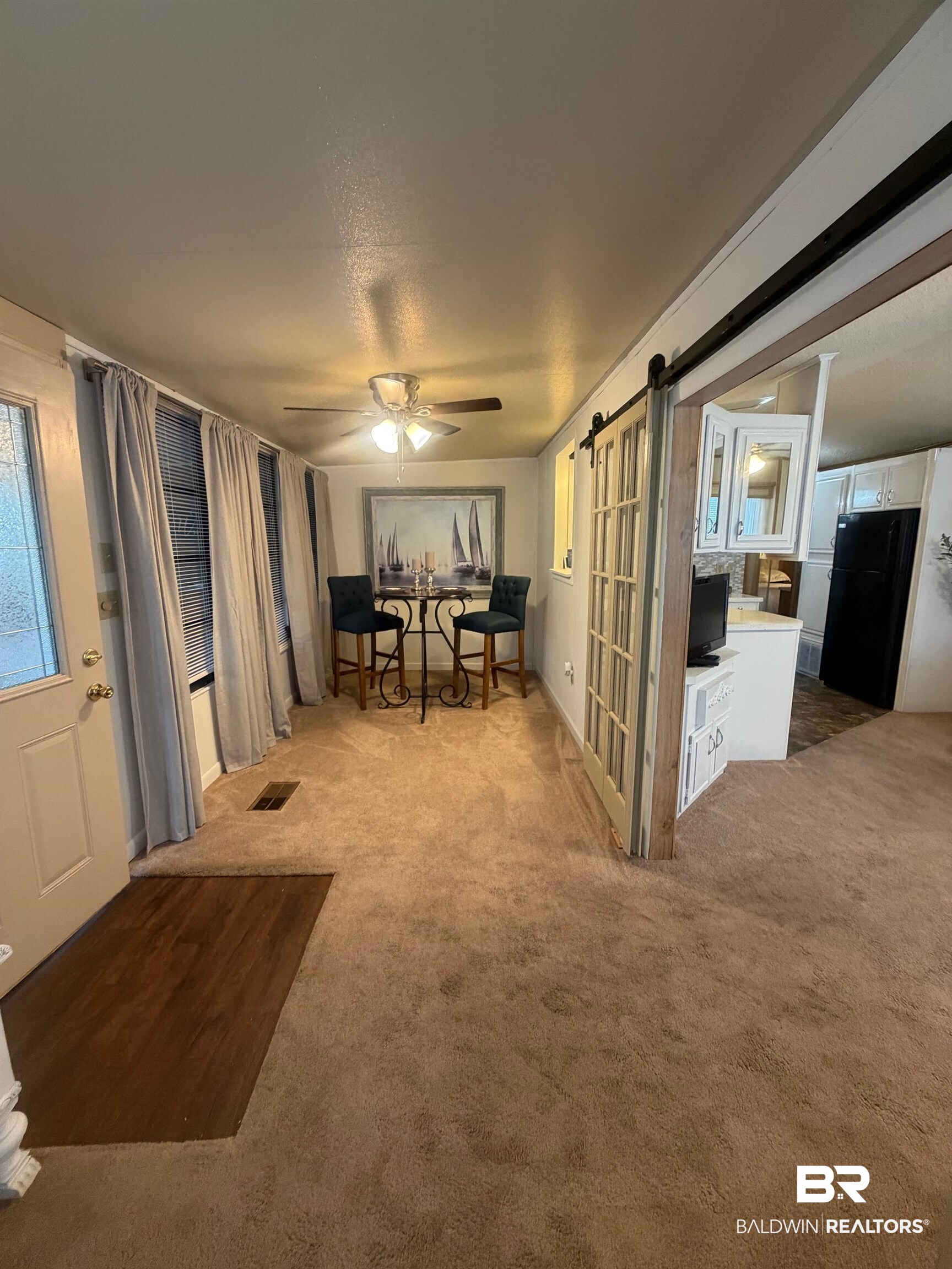 685 Escambia Loop Lillian, AL 36549 - Photo 4 of 43 Dining space with a barn door, light colored carpet, and a ceiling fan