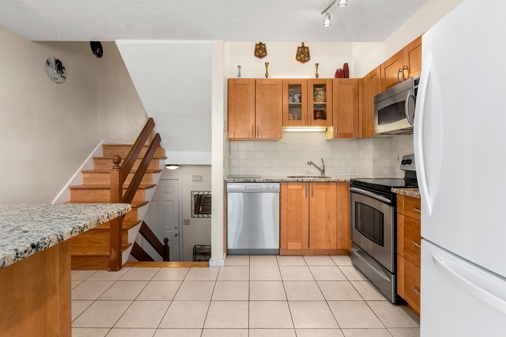 48 Regent Circle, Unit 48 Brookline, MA 02445 - Photo 2 of 14 a kitchen with stainless steel appliances granite countertop a stove and a sink