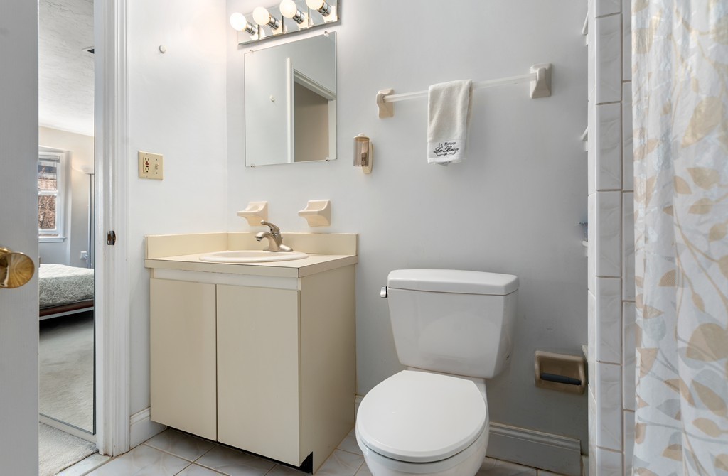 48 Regent Circle, Unit 48 Brookline, MA 02445 - Photo 10 of 14 a white toilet sitting next to a bathroom sink